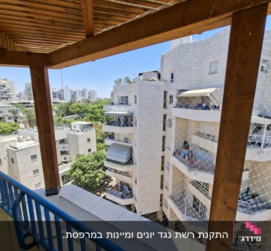התקנת רשת שקופה נגד יונים במרפסת עם פרגולת עץ
